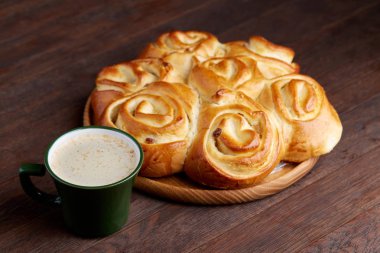 Kremalı kahve Kupası ev yapımı gül ekmek vintage ahşap arka plan, yakın çekim, seçici odak ile