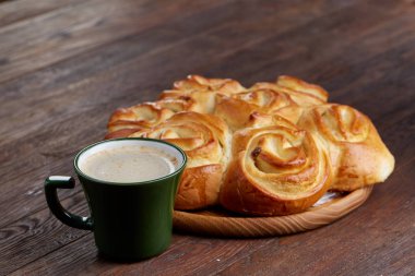 Kremalı kahve Kupası ev yapımı gül ekmek vintage ahşap arka plan, yakın çekim, seçici odak ile