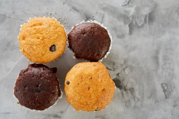 Lekkere muffins gerangschikt in patroon op licht gestructureerde achtergrond, close-up, ondiepe diepte van veld, selectieve aandacht. — Stockfoto