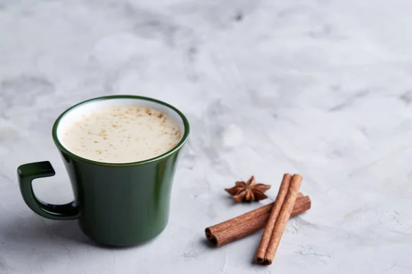 Ceașcă de cafea cremoasă cu scorțișoară și anason stelar pe un fundal texturat alb, vedere de sus, aproape, focalizare selectivă — Fotografie, imagine de stoc