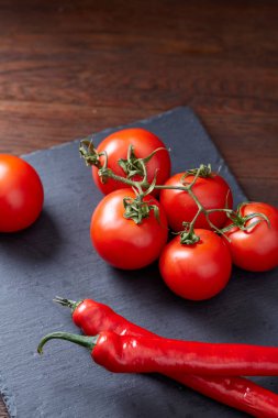 Taze üzüm domates, biber ve tuz ahşap zemin, seçici odak üzerine tahta kaşık ile vejetaryen natürmort