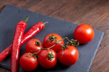 Taze üzüm domates, biber ve tuz ahşap zemin, seçici odak üzerine tahta kaşık ile vejetaryen natürmort