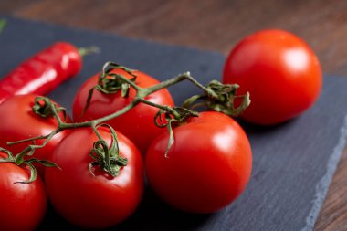 Taze üzüm domates, biber ve tuz ahşap zemin, seçici odak üzerine tahta kaşık ile vejetaryen natürmort