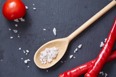 Taze üzüm domates, biber ve tuz ahşap zemin, seçici odak üzerine tahta kaşık ile vejetaryen natürmort