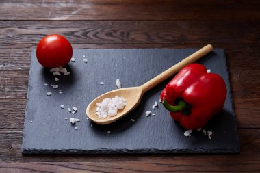 Taze üzüm domates, biber ve tuz ahşap zemin, seçici odak üzerine tahta kaşık ile vejetaryen natürmort