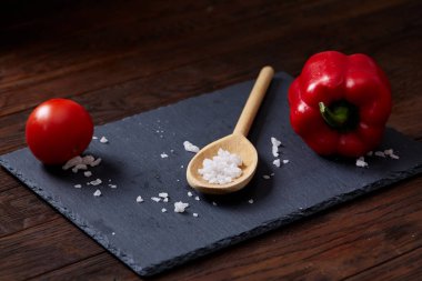 Taze üzüm domates, biber ve tuz ahşap zemin, seçici odak üzerine tahta kaşık ile vejetaryen natürmort