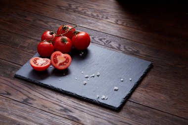 Taze üzüm domates, biber ve tuz ahşap zemin, seçici odak üzerine tahta kaşık ile vejetaryen natürmort