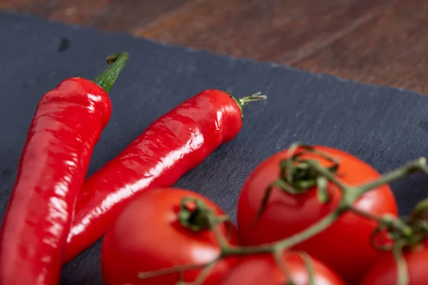 Vegetariano ainda vida com tomates de uva fresca, pimenta e sal em colher de madeira em fundo de madeira, foco seletivo — Fotografia de Stock