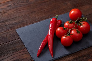 Taze üzüm domates, biber ve tuz ahşap zemin, seçici odak üzerine tahta kaşık ile vejetaryen natürmort