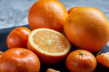 Yüksek açı natürmort görünümünü dilimlenmiş yakut portakal ve mandalina birlikte taşlı tahtada düzenlenmiş