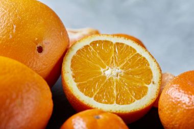 Yüksek açı natürmort görünümünü dilimlenmiş yakut portakal ve mandalina birlikte taşlı tahtada düzenlenmiş