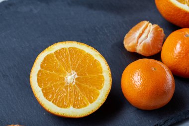 Yüksek açı natürmort görünümünü dilimlenmiş yakut portakal ve mandalina birlikte taşlı tahtada düzenlenmiş