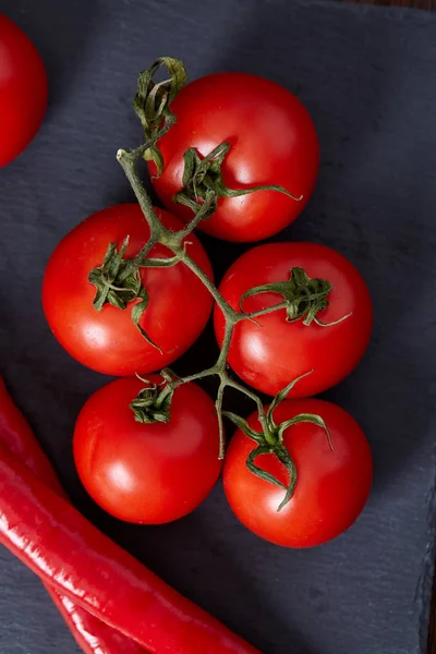 Bodegón vegetariano con tomates frescos de uva, pimienta y sal en cuchara de madera sobre fondo de madera, enfoque selectivo — Foto de Stock