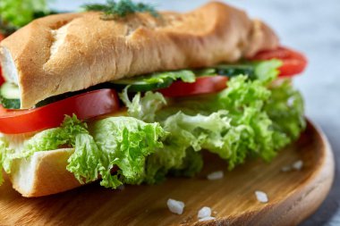 Marul, domates ve peynir ile taze sandviç ahşap beyaz dokulu arka plan üzerinde seçici odak tabakta