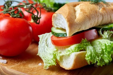 Marul, domates ve peynir ile taze sandviç ahşap beyaz dokulu arka plan üzerinde seçici odak tabakta