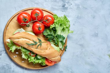 Marul, domates ve peynir ile taze sandviç ahşap beyaz dokulu arka plan üzerinde seçici odak tabakta