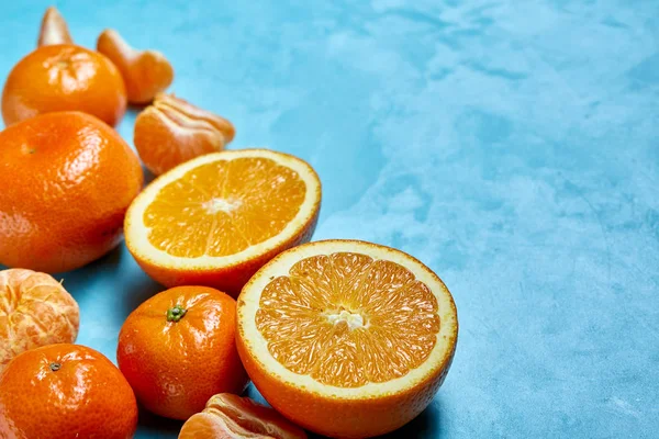 Taze narenciye meyve suyu ya da iki yüzlü yapmak mavi dokulu arka plan, üstten görünüm, seçici odak üzerinde çeşitli.