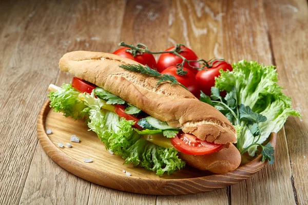 Panino fresco con lattuga, pomodori, formaggio su piatto di legno, tazza di caffè su sfondo rustico, focus selettivo — Foto Stock