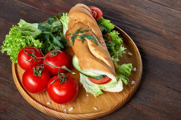 Panino fresco con lattuga, pomodori, formaggio su piatto di legno, tazza di caffè su sfondo rustico, focus selettivo — Foto Stock