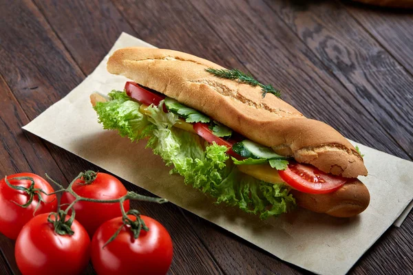 Panino fresco con lattuga, pomodori, formaggio su piatto di legno, tazza di caffè su sfondo rustico, focus selettivo — Foto Stock