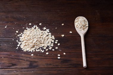 Tahta kaşık ve yulaf vintage ahşap arka plan üzerinde yığın kopyalama alanı, üstten görünüm, yakın çekim, seçici odak