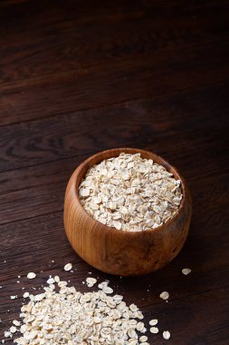 Kase ve izole ahşap arka plan, yakın çekim, üstten görünüm, seçici odak tahta kaşık yulaf gevreği.