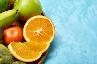 Bir mavi arka plan, seçici odak, yakın çekim, en iyi görünümü ahşap bir tabak içinde olgunlaşmış taze meyve