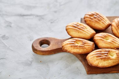 Bademli kurabiyeleri ve ahşap kesme tahtası beyaz arka plan, yakın çekim, seçici odak üzerinde çiğ badem.