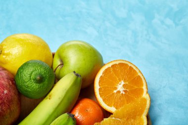 Bir mavi arka plan, seçici odak, yakın çekim, en iyi görünümü ahşap bir tabak içinde olgunlaşmış taze meyve