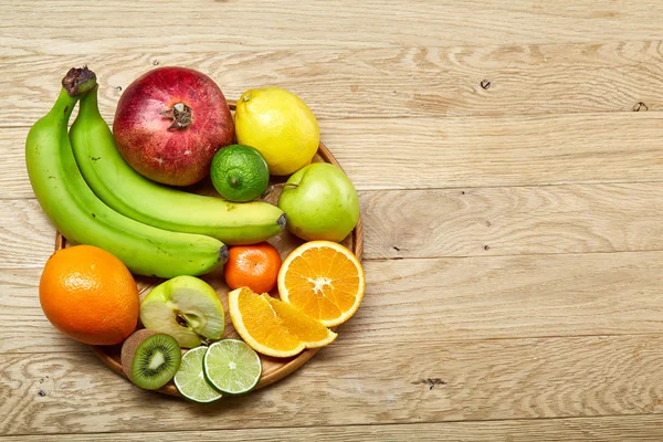 Mogna frukter i en träplatta på en ljus trä bakgrund, selektivt fokus, närbild, top view — Stockfoto