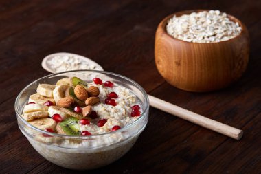 Meyve, kase ve kaşık yulaf gevreği, seçici odak, yakın çekim ile diyet kahvaltı yulaf ezmesi