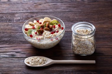 Meyve, kase ve kaşık yulaf gevreği, seçici odak, yakın çekim ile diyet kahvaltı yulaf ezmesi