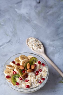 Meyve, kase ve kaşık yulaf gevreği, seçici odak, yakın çekim ile diyet kahvaltı yulaf ezmesi