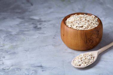 Kase ve izole ahşap arka plan, yakın çekim, üstten görünüm, seçici odak tahta kaşık yulaf gevreği.