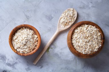 Kase ve izole ahşap arka plan, yakın çekim, üstten görünüm, seçici odak tahta kaşık yulaf gevreği.