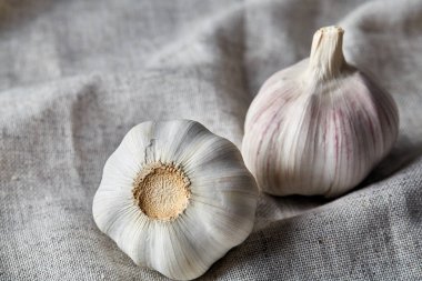 Düzenlenmiş bir pamuk masa örtüsü, alan, seçici odak, makro sığ derinliği iki sarımsak ampuller görünümünü kapat