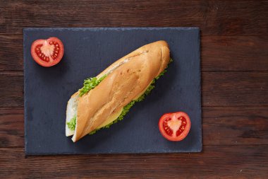 Taze ve lezzetli sandviç peyniri ve sebze kesme tahtası üzerinde beyaz dokulu arka plan, seçici odak üzerinde.