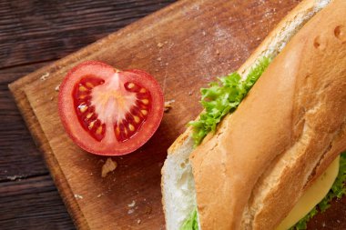 Taze ve lezzetli sandviç peyniri ve sebze kesme tahtası üzerinde beyaz dokulu arka plan, seçici odak üzerinde.