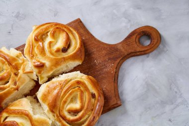 Ev yapımı gül buns ahşap kesim üzerinde kurulu beyaz dokulu arka plan, yakın çekim, sığ derinlik-in tarla üzerinde