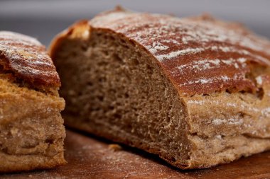 Taze çavdar ekmeği somun bir Ahşap doğrama üzerinde kurulu beyaz dokulu arka plan sığ derinlik-in tarla