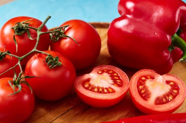 Domates grup ve yarısı ve tatlı biber ahşap plaka, üstten görünüm, yakın çekim, seçici odak bileşimi.