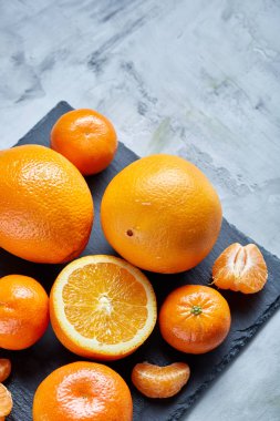 Taze mandalina ve turuncu masa, yakın çekim kesme üzerinde tam ve yarım kesilmiş