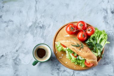 Marul, domates, peynir ahşap plaka üzerinde kahve beyaz arka planda, seçici odak ile taze sandviç