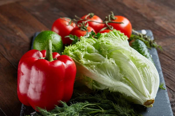 Gros plan nature morte de légumes frais et d'herbes sur fond rustique en bois, vue de dessus, mise au point sélective . — Photo