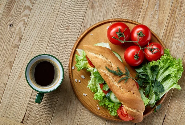 Friss saláta, paradicsom, sajt, a fából készült lemez, csésze kávét a rusztikus háttér, szelektív összpontosít szendvics — Stock Fotó