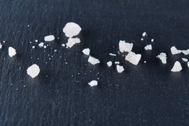 Karanlık kartı üzerindeki beyaz arka plan, yakın çekim, en iyi görünüm, makro, seçici odak tuz kristallerinin yığını