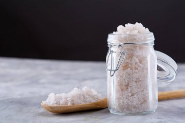 Spa kavramı. Cam kavanozdan dökme texrured arka plan, yakın çekim, seçici odak banyo tuzu