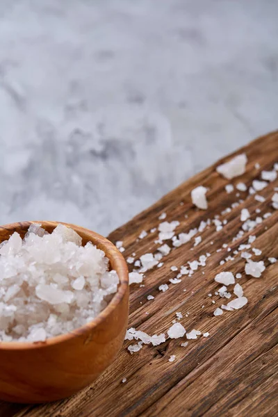 Büyük beyaz deniz tuzu bir doğal ahşap kase beyaz arka plan, üstten görünüm, yakın çekim, seçici odak