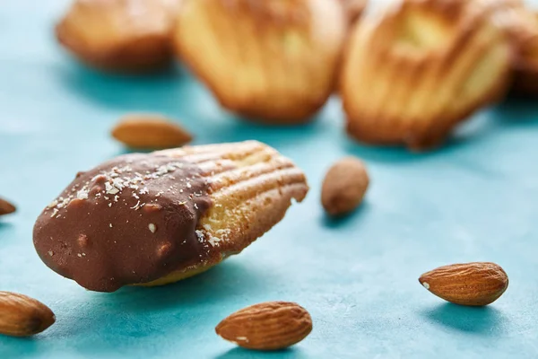 Yummy almond cookies arranged on blue background, close-up, selective focus, top view.