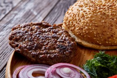 Lezzetli hamburger malzemeler sanatsal organize ahşap plaka, yakın çekim, en iyi görünüm, seçici odak